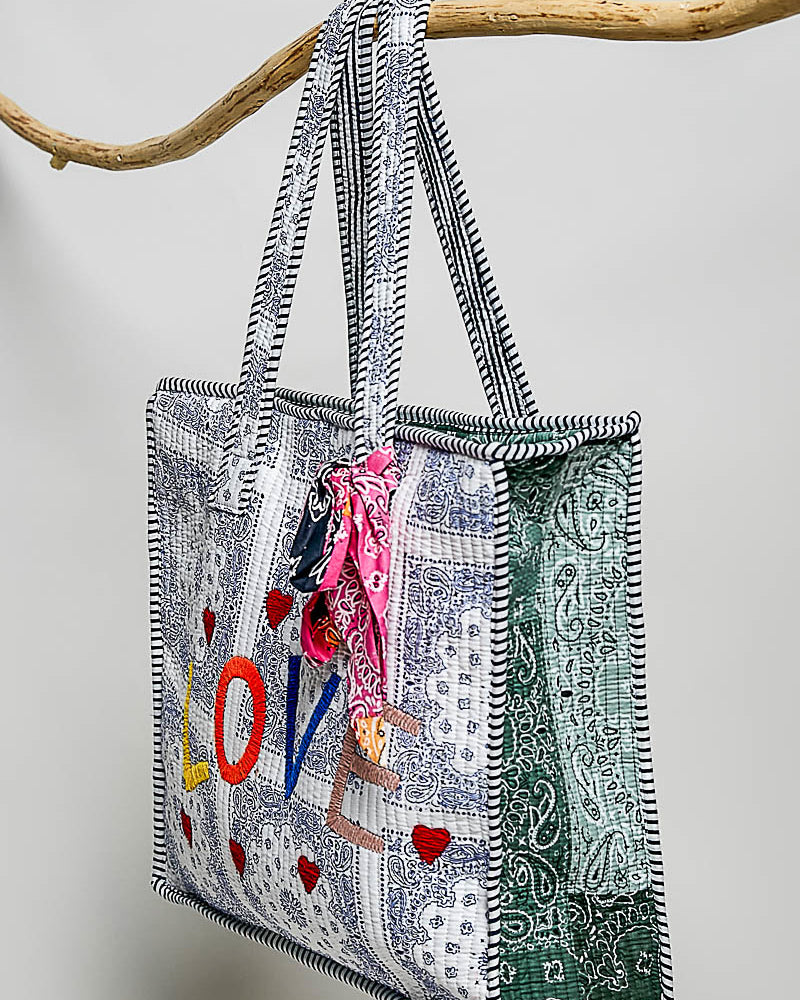 oversized tote bag with a quilted texture and embroidered "love" in bold colors