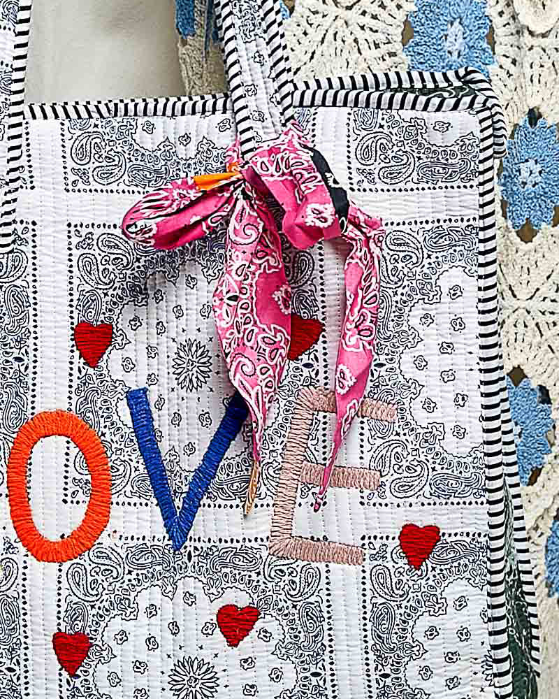 oversized tote bag with a quilted texture and embroidered "love" in bold colors