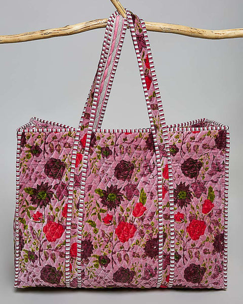 oversized quilted tote bag in a purple floral pattern with striped details. 