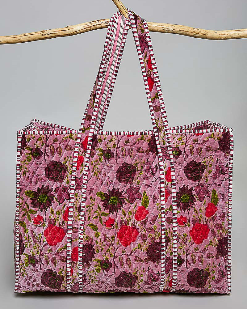 oversized quilted tote bag in a purple floral pattern with striped details. 
