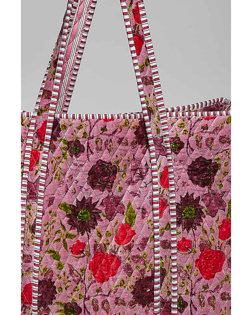 oversized quilted tote bag in a purple floral pattern with striped details. 