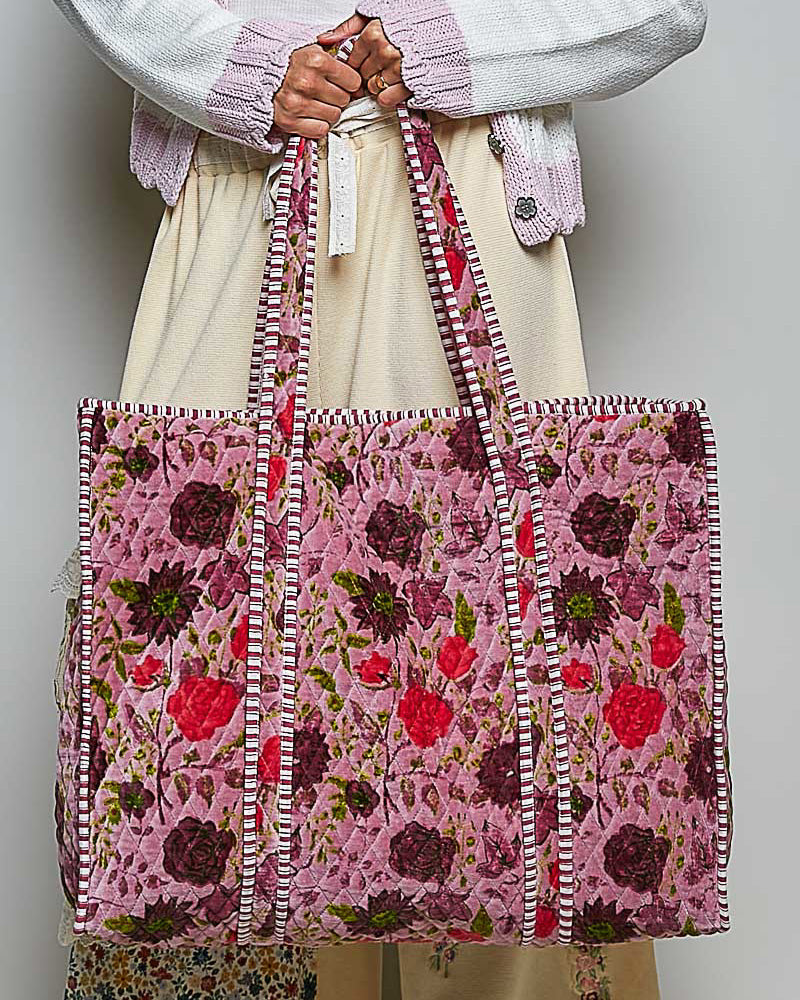 oversized quilted tote bag in a purple floral pattern with striped details. 