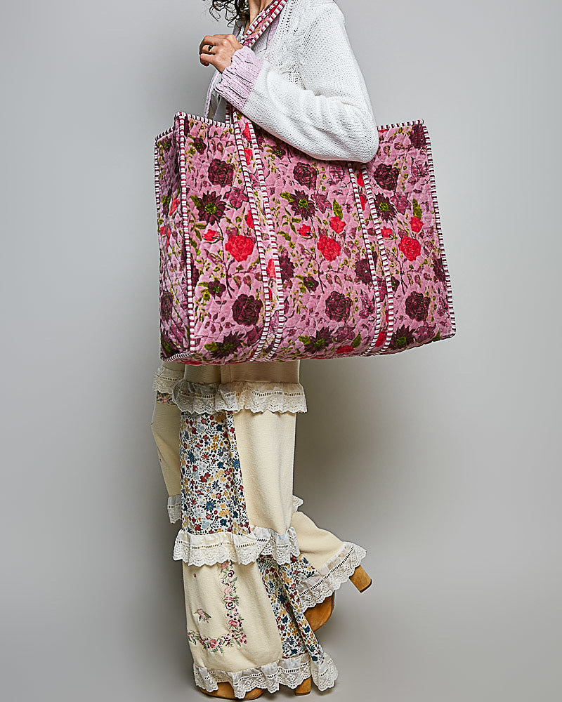 oversized quilted tote bag in a purple floral pattern with striped details. 