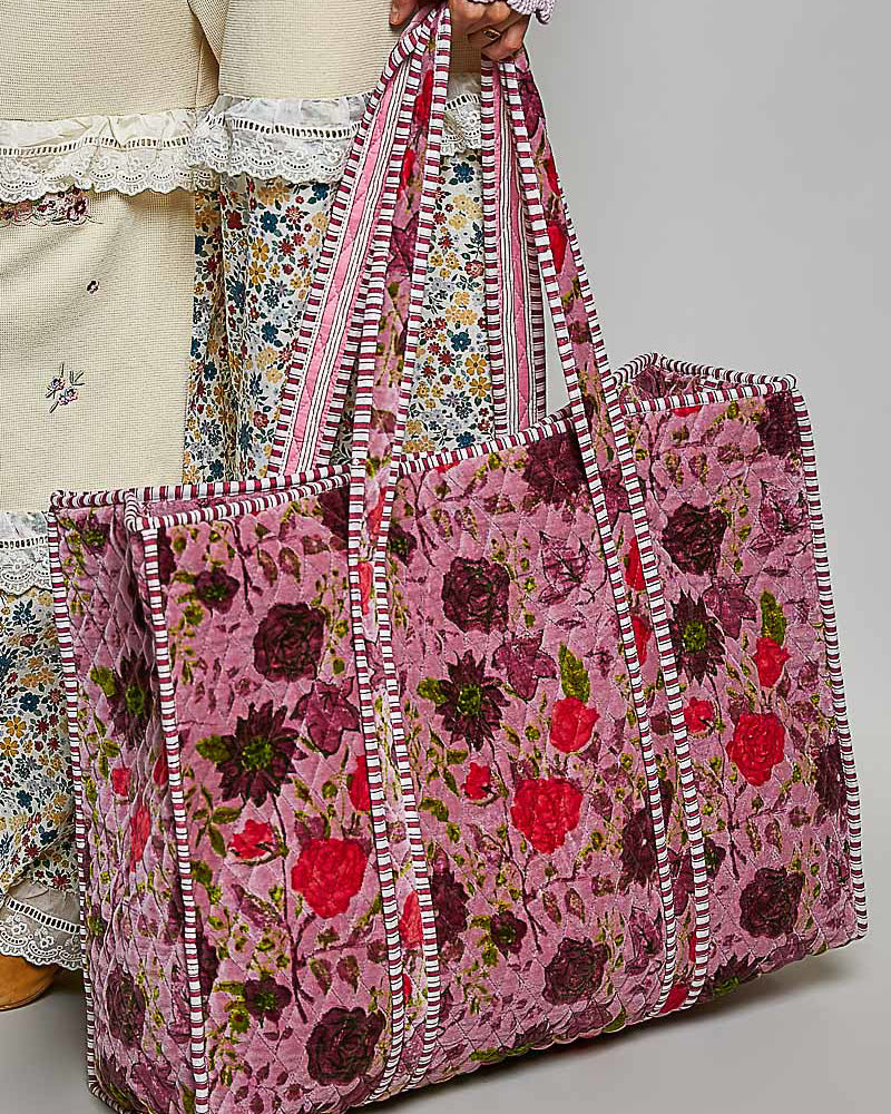 oversized quilted tote bag in a purple floral pattern with striped details. 
