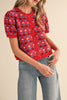 short sleeve button up sweater in red with a colorful floral pattern in cream, burgundy, and light blue.