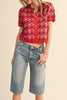 short sleeve button up sweater in red with a colorful floral pattern in cream, burgundy, and light blue.
