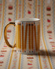 white porcelain mug with a pencil design and metallic gold detailing
