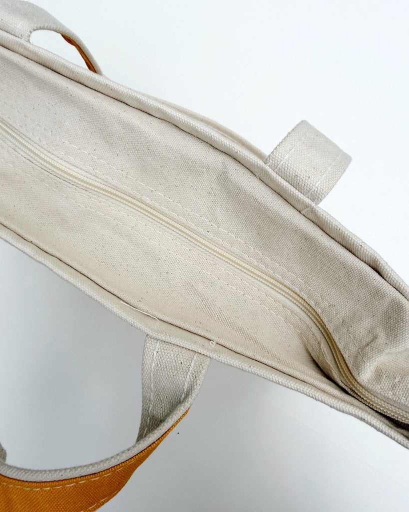 zippered top of mustard yellow canvas tote