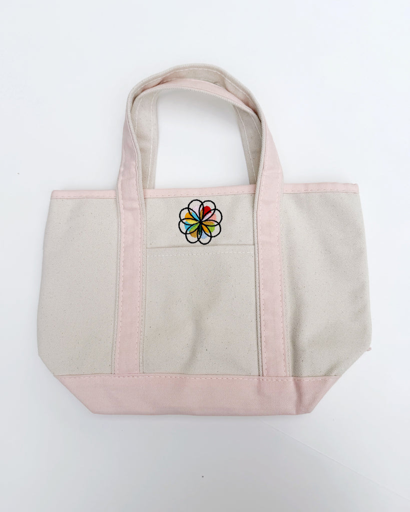 small canvas tote bag with pink straps and embroidered personify flower