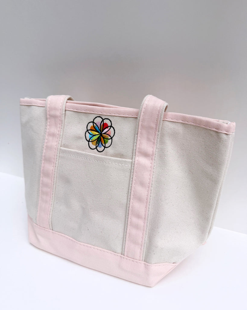 small canvas tote bag with pink straps and embroidered personify flower