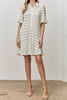 white mini dress with black trimmed ruffle details throughout