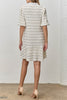 white mini dress with black trimmed ruffle details throughout