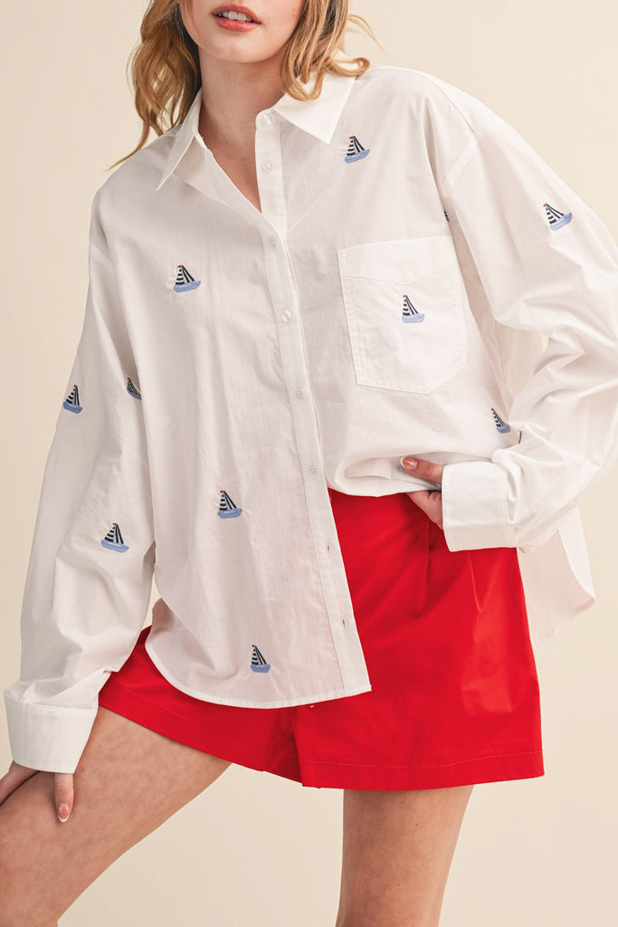 menswear-inspired button down top in crisp white with embroidered sailboats throughout
