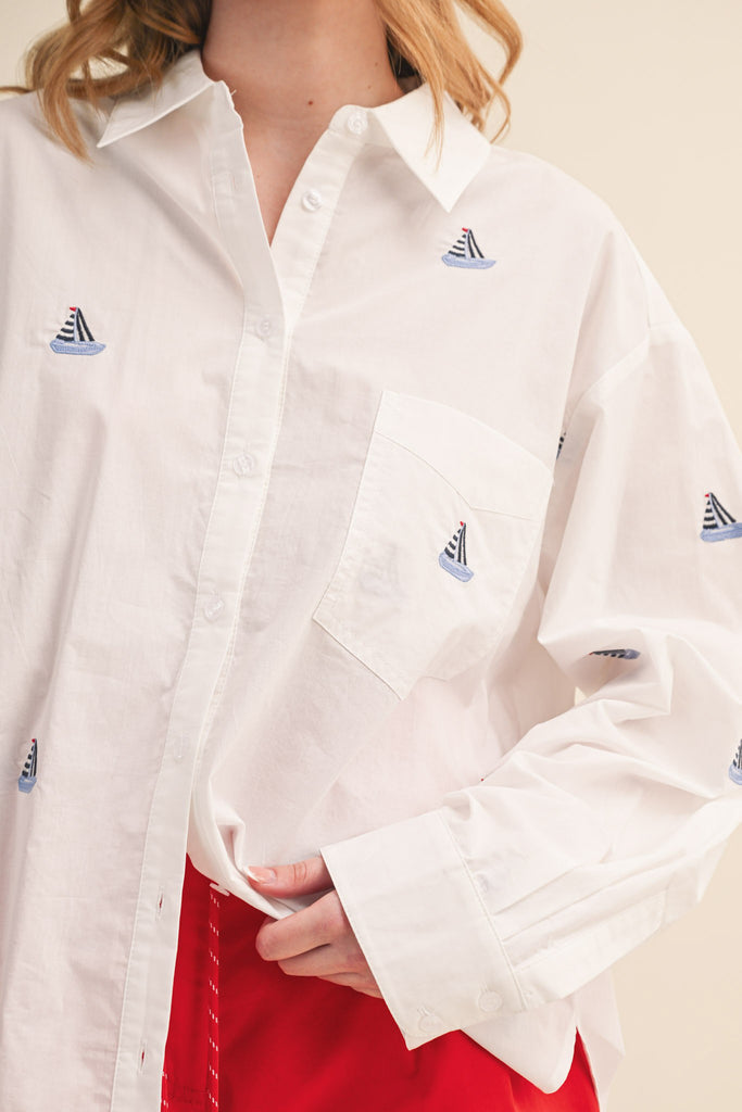menswear-inspired button down top in crisp white with embroidered sailboats throughout