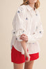 menswear-inspired button down top in crisp white with embroidered sailboats throughout