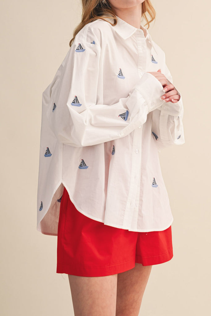 menswear-inspired button down top in crisp white with embroidered sailboats throughout