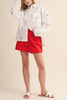 menswear-inspired button down top in crisp white with embroidered sailboats throughout