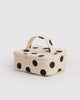 small cosmetic case in a cream and black polka dot pattern