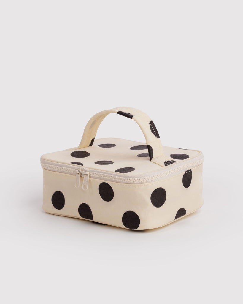 small cosmetic case in a cream and black polka dot pattern