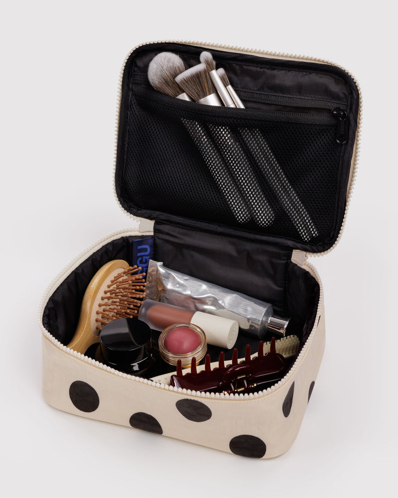 small cosmetic case in a cream and black polka dot pattern