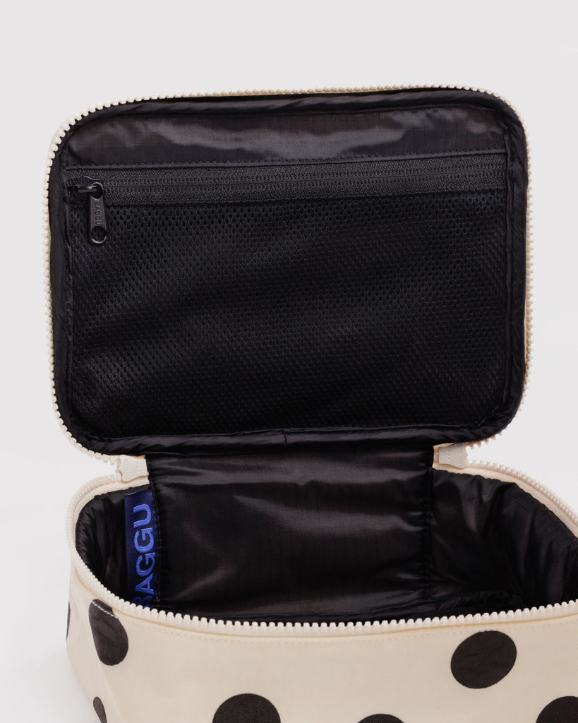 small cosmetic case in a cream and black polka dot pattern