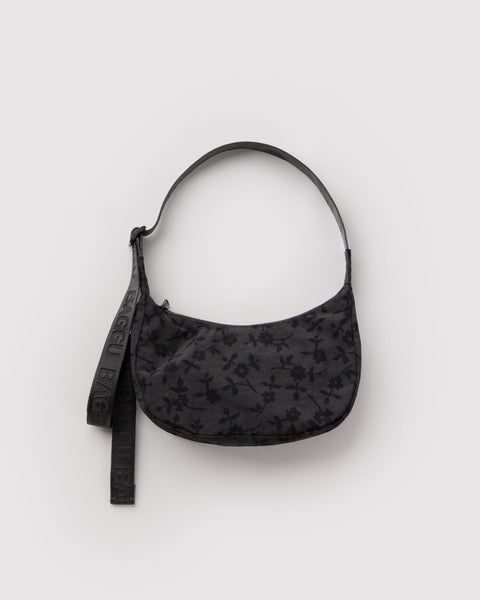 small nylon crescent bag from baggu in a charcoal colored ditsy floral pattern