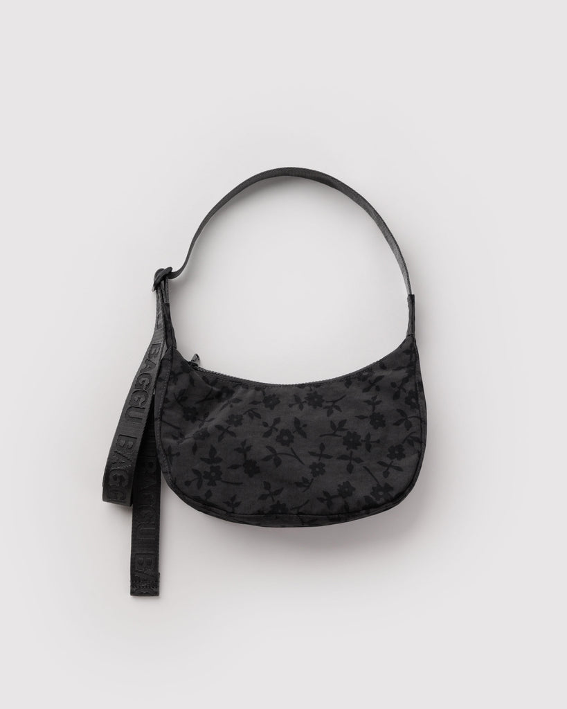 small nylon crescent bag from baggu in a charcoal colored ditsy floral pattern
