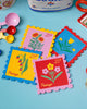 set of four leatherette coasters in the shape of colorful postage stamps