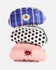 Three hair claw clips stacked vertically on a light gray background. The top clip is blue with pink stripes and a white daisy flower.