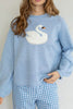 baby blue sweater with a white swan graphic