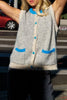 knit sweater vest in cream and light grey with bright blue detailing on buttons, neckline, and pockets