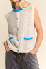 knit sweater vest in cream and light grey with bright blue detailing on buttons, neckline, and pockets