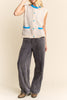 knit sweater vest in cream and light grey with bright blue detailing on buttons, neckline, and pockets
