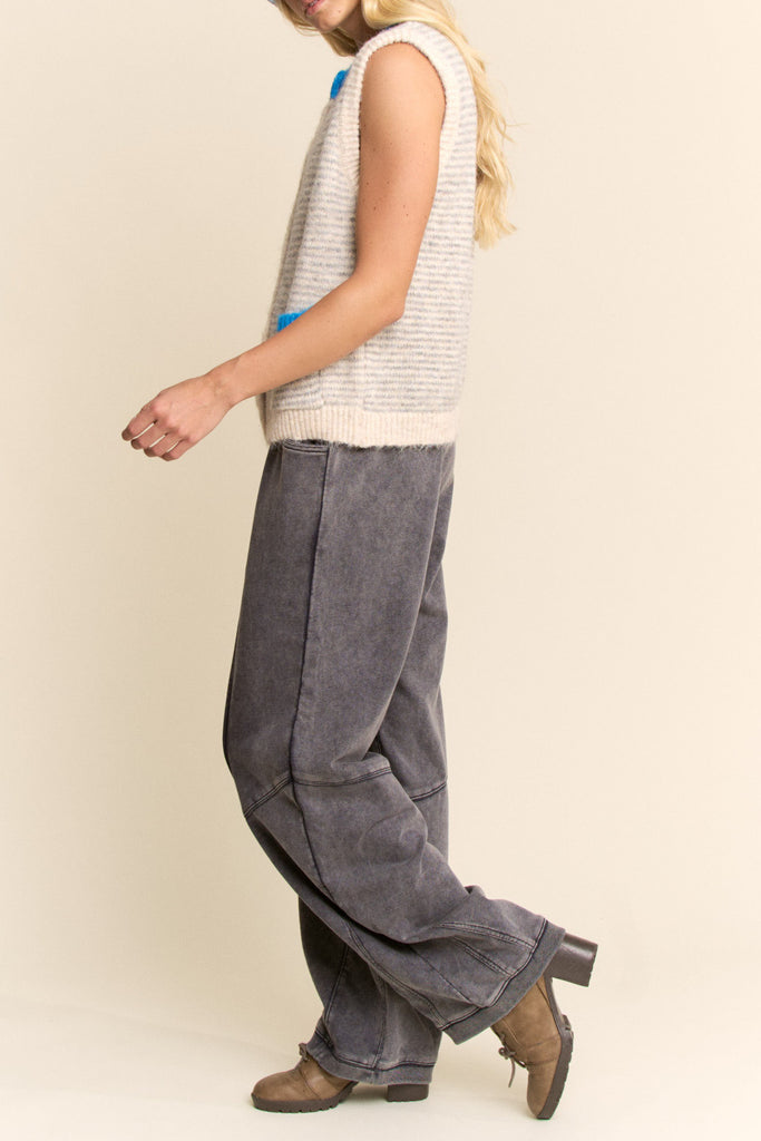 knit sweater vest in cream and light grey with bright blue detailing on buttons, neckline, and pockets