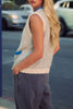 knit sweater vest in cream and light grey with bright blue detailing on buttons, neckline, and pockets