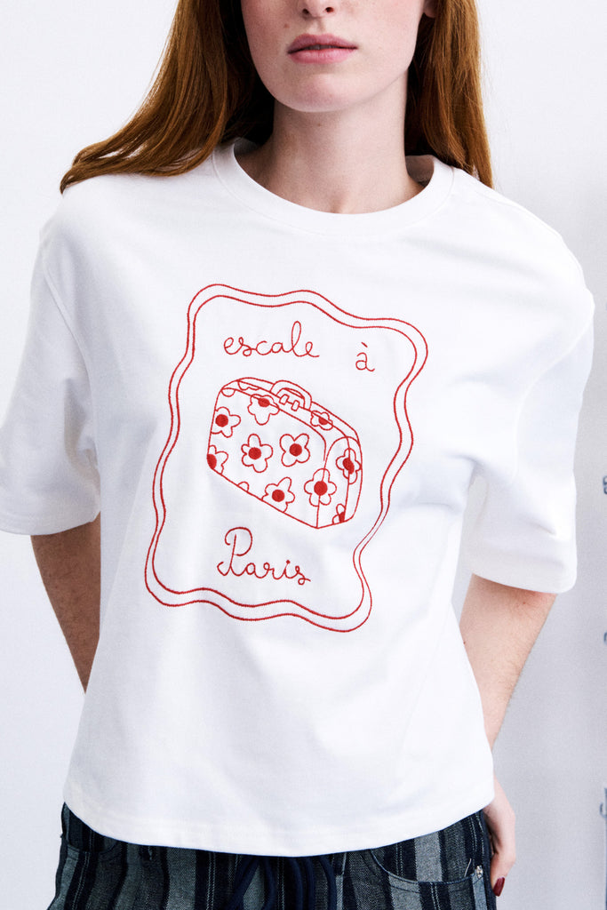 white tee with a travel-inspired embroidered design
