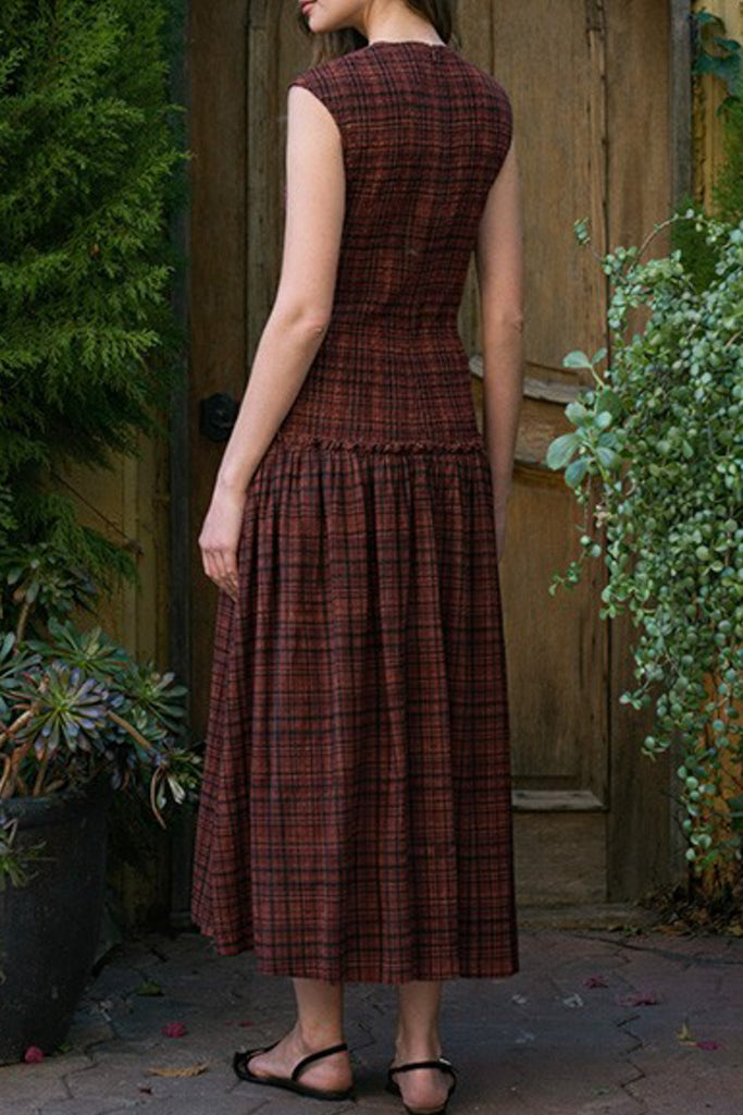 striking midi dress in a dark plaid pattern with smocked details