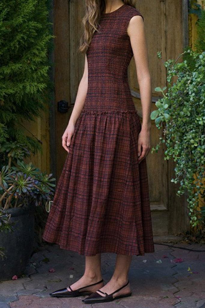 striking midi dress in a dark plaid pattern with smocked details