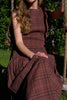 striking midi dress in a dark plaid pattern with smocked details